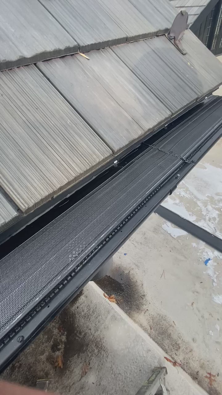 Aluminum micro-mesh gutter guard installed inside the gutter demonstrating water flow and debris filtration