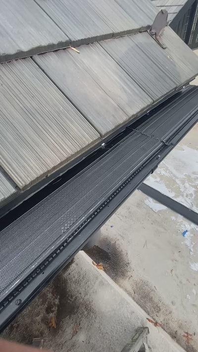 Aluminum micro-mesh gutter guard installed inside the gutter demonstrating water flow and debris filtration